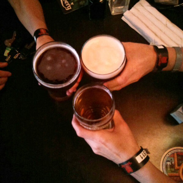 Three beers being raised in a cheer