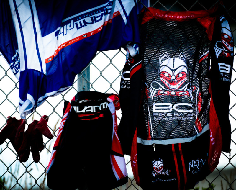 racing jerseys hanging on a fence to dry