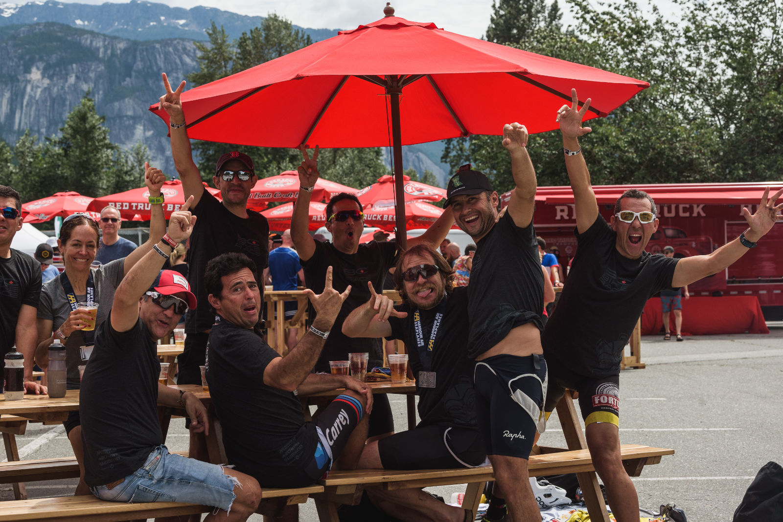 group of racers under a red umbrella with the Red Truck Brewery truck in the background