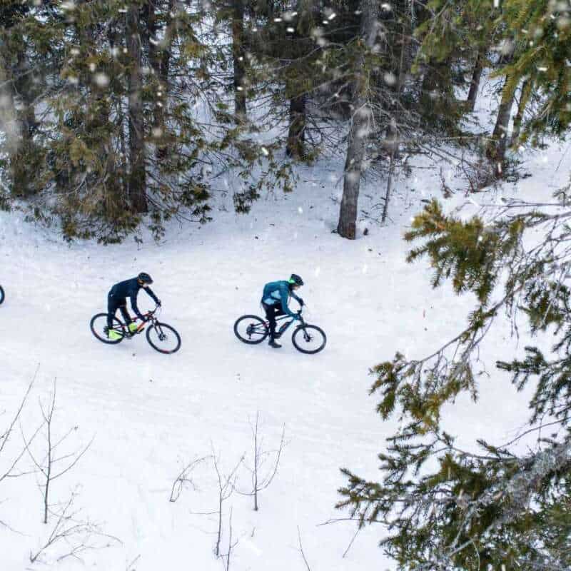 cyclists riding in the snow