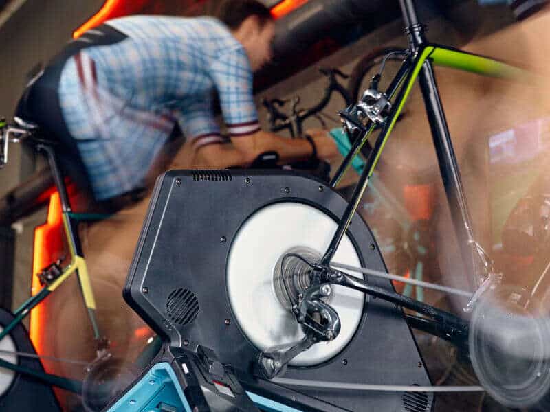 Man exercising cycling gym machine trainer equipment. Bike training. Motion blur shot